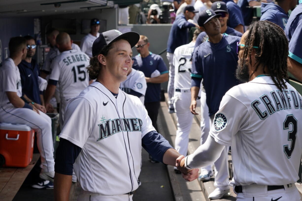 Seattle Mariners starting pitcher Logan Gilbert is congratulated by J.P. Crawford (3) after throwing against the New York Yankees through seven innings of a baseball game Thursday, July 8, 2021, in Seattle.