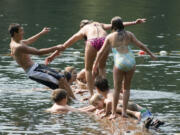 Swimmers play on a floating log at Battle Ground Lake State Park.