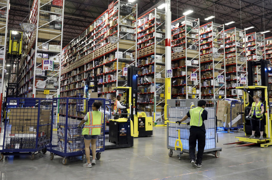 Workers pick items before filling boxes to ship at an Amazon fulfillment center, Aug. 1, 2017, in Romeoville. The company is changing its drug testing policy and would no longer disqualify people from working at Amazon if they tested positive for marijuana.