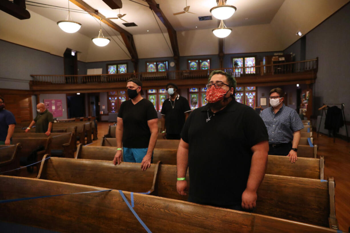 Eli Irizarry, foreground, and others sing as the Chicago Gay Men's Chorus rehearses at Lake View Presbyterian Church in Chicago. The group was rehearsing before a weekend performance at Northalsted Market Days festival.