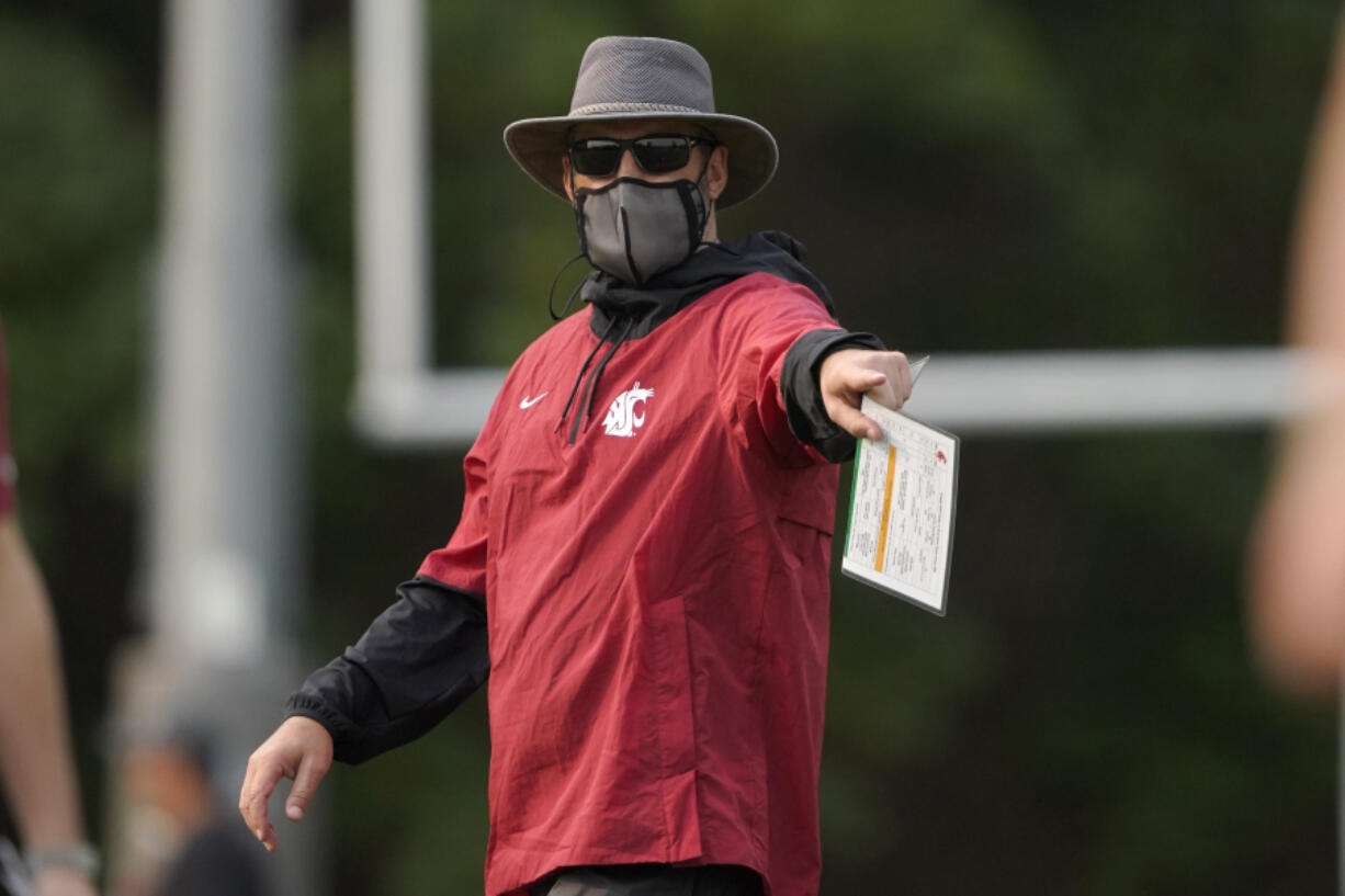 Washington State head coach Nick Rolovich wears a mask as he gives directions during a recent football practice. Rolovich remains the only unvaccinated head football coach in the Pac-12. (AP Photo/Ted S.