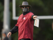 Washington State head coach Nick Rolovich wears a mask as he gives directions during a recent football practice. Rolovich remains the only unvaccinated head football coach in the Pac-12. (AP Photo/Ted S.