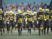 Oregon players take the field at an empty Autzen Stadium for an NCAA college football game Saturday, Nov. 7, 2020, in Eugene, Ore.