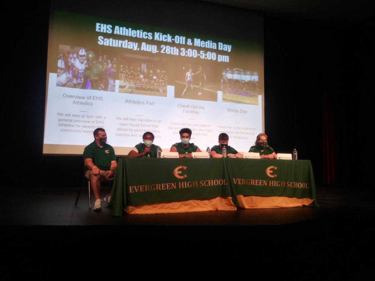 Evergreen High School football coach and athletic director Christian Swain sits with football players (from left) Jonathan Landry, David Kailea, Kyle Norton and Gary McCulley at Evergreen's Athletics Kick-off and Media Day.