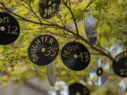 Martha Wiley of Vancouver hangs a compact disc from a tree in her yard each time someone in Clark County dies of COVID-19. She said she's running out of room.