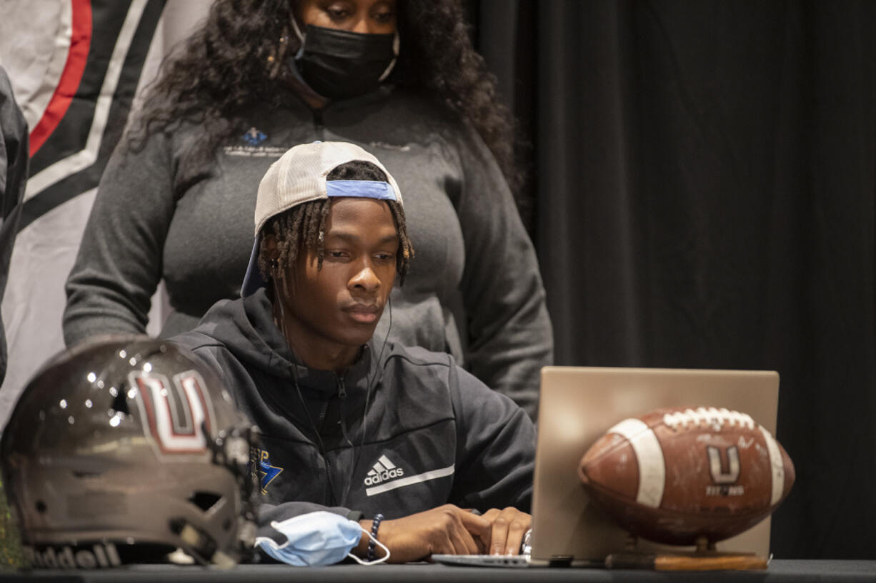 Tobias Merriweather, center, is joined by his mother, Beverly Merriweather, as he announces his college choice.