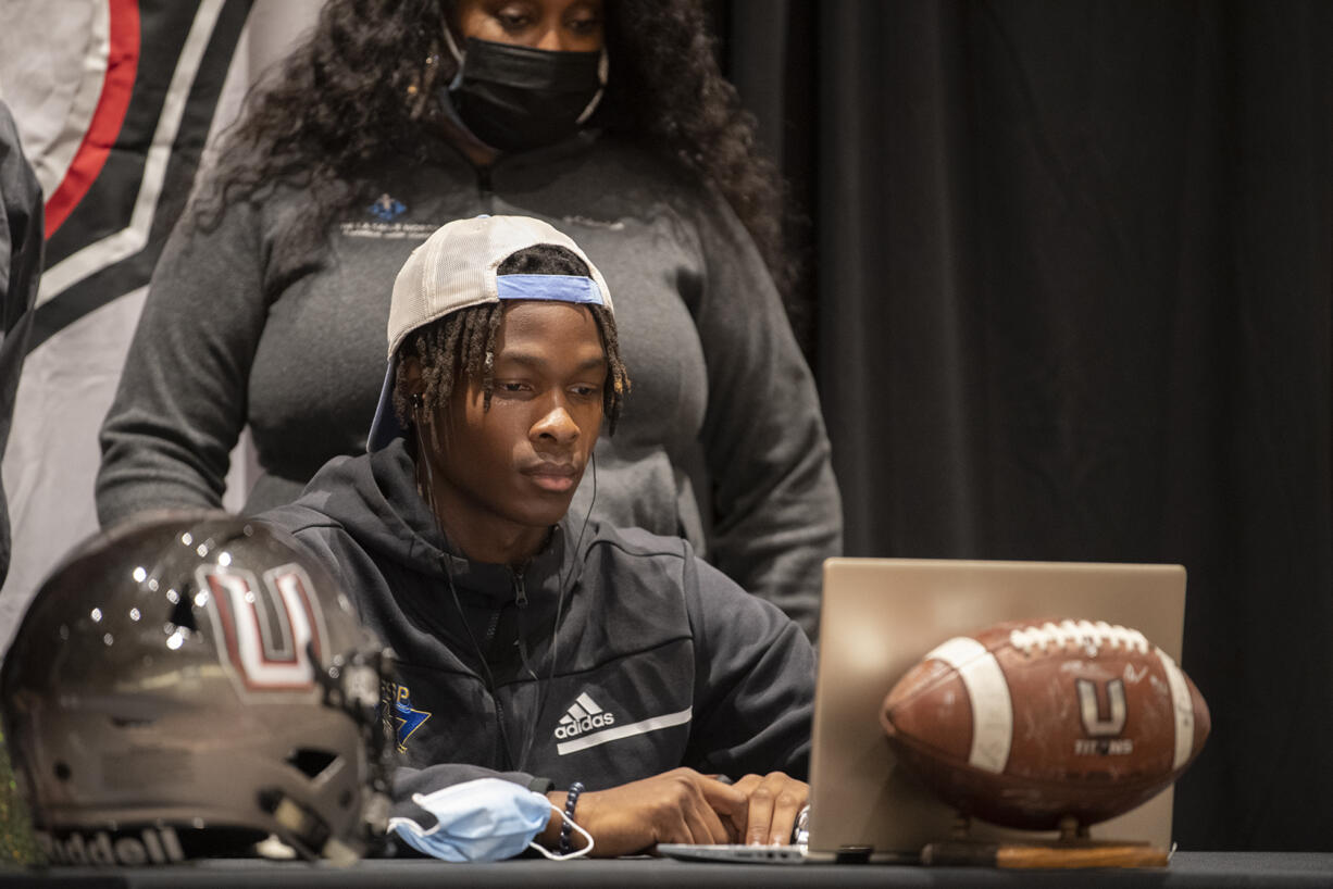 Tobias Merriweather, center, is joined by his mother, Beverly Merriweather, as he announces his college choice at Union High School on Wednesday afternoon, Aug. 4, 2021.