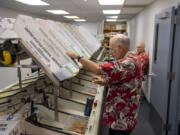 Elections office employee Brian Hopper sorts envelopes containing returned ballots at the elections office on Tuesday morning.