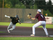 Ridgefields' Doyle Kayne waits for the ball as Cowlitz' Rikuu Nishida returns to first base at Ridgefield Outdoor Recreation Complex on Wednesday, August 4, 2021.