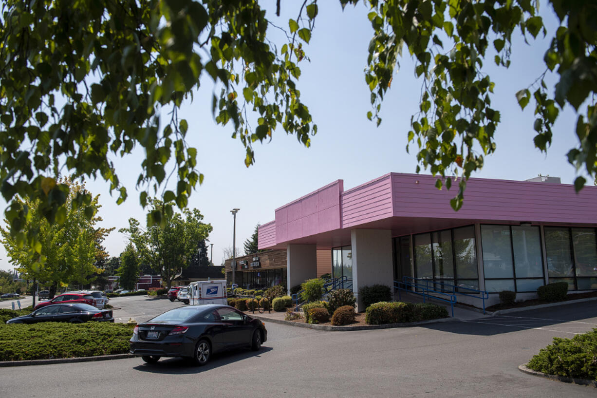 Voodoo Doughnut plans to open a Vancouver location in this former bank building, now painted pink, near Vancouver Mall. At top, a neon sign that adorns the Voodoo Doughnut store in Portland's Old Town-Chinatown neighborhood.