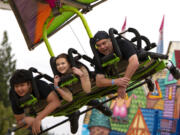 Jordan Higgins, from left, Kyra Tiaga and Ted Tiaga smile as they ride "Cliff Hanger" on Saturday at the Clark County Fairgrounds. While the fair was canceled this year, the Clark County Event Center is hosting several events in the Family Fun Series, including a carnival with rides and games. At top, inflatable aliens await the winners of the hammer game.