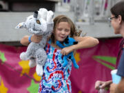 Alivia Pietrzykowski, 8, jumps for joy after winning a giant stuffed dog during a carnival on Saturday at the Clark County Fairgrounds. The carnival will run through Aug. 15 and is open until 11 p.m. each night.