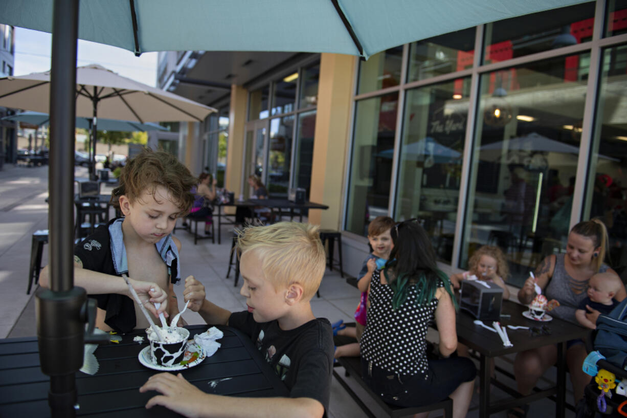 Ronnie Melton, 8, of Woodland, left, dives into an order of Cookies and Worms with his brother, Jackson Beintker-Melton, 9, at The Yard at The Waterfront Vancouver development earlier this month. The shop formally opened last weekend.