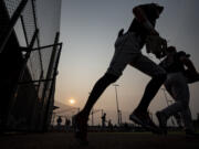 Players take the field under smoky skies Saturday, Aug. 14, 2021, during a playoff game between the Ridgefield Raptors and the Corvallis Knights at the Ridgefield Outdoor Recreation Complex.