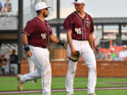 Ridgefield first baseman Isaac Lovings, left, congratulates pitcher Brock Gillis on a good first inning Saturday, Aug. 14, 2021, during the Raptors' 13-6 loss to Corvallis in a playoff game at the Ridgefield Outdoor Recreation Complex.