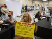 A person dressed as Sasquatch greets those seeking employment at a job fair in August 2021. The fair drew more than 100 employers looking to meet with job seekers to the Clark County Event Center at the Fairgrounds. At top, Henry Pio of Hazel Dell, from left, talks with Congresswoman Jaime Herrera Beutler as she greets his stepdaughter, Geovanna Alarcon, who is looking for employment.