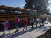 Young students practice social distancing after leaving the school bus for their first day of class at Marrion Elementary School on Tuesday. Thousands of students across multiple Clark County school districts, including Evergreen and Vancouver, began classes for the 2021-22 school year Tuesday amid another year impacted by COVID-19. More districts start Wednesday.