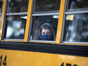 First-grader Alishan Krekic peeks out from his spot on the school bus as he arrives for classes at Marrion Elementary School on Tuesday morning, Aug. 31, 2021.