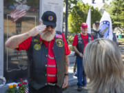 Patriot Guard Rider Nick Kinler salutes Amber Howard, widow of U.S. Army National Guard Sgt. Bryce D. Howard, after presenting her with a tracing of her husband's name on an Illinois war memorial during a ceremony honoring the fallen soldier's memory Saturday at the Clark County Veterans War Memorial. Amber accepted the gift with her sons, Caleb, 21, and Ryen, 17.