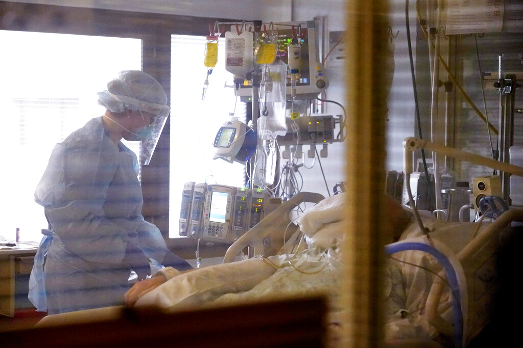 FILE - In this Jan. 26, 2021, file photo, registered nurse Andraya Zelle treats a patient in the COVID intensive care unit at UW Medical Center-Montlake in Seattle.