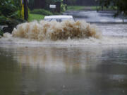 A car attempts to drive through flood waters near Peachtree Creek near Atlanta, as Tropical Storm Fred makes its way through north and central Georgia on Tuesday, Aug. 17, 2021.