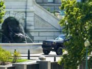 A pickup truck is parked on the sidewalk in front of the Library of Congress' Thomas Jefferson Building, as seen from a window of the U.S. Capitol, Thursday, Aug. 19, 2021, in Washington. A man sitting in the pickup truck outside the Library of Congress has told police that he has a bomb, and that's led to a massive law enforcement response to determine whether it's an operable explosive device.