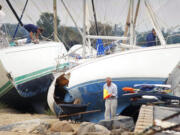 FILE - In this Aug. 20, 1991, file photo, boat owners gather their belongings along the shore in Dartmouth, Mass., after Hurricane Bob swept through southern Massachusetts. New Englanders, bracing for their first direct hit by a hurricane in 30 years, are taking precautions as Tropical Storm Henri barrels toward the southern New England coast.