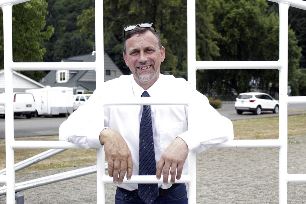 FILE - In this Aug. 20, 2021, file photo, Alsea School District Superintendent Marc Thielman poses for a portrait on the school campus in Alsea, Ore. With COVID-19 cases and hospitalizations surging in Oregon at least three school districts have pushed back their start date. The Alsea School District in Benton County was set to start Monday. But on Aug. 21, Superintendent Thielman shared a message with families, announcing a delay to the school year due to an elementary staff member testing positive for COVID-19.