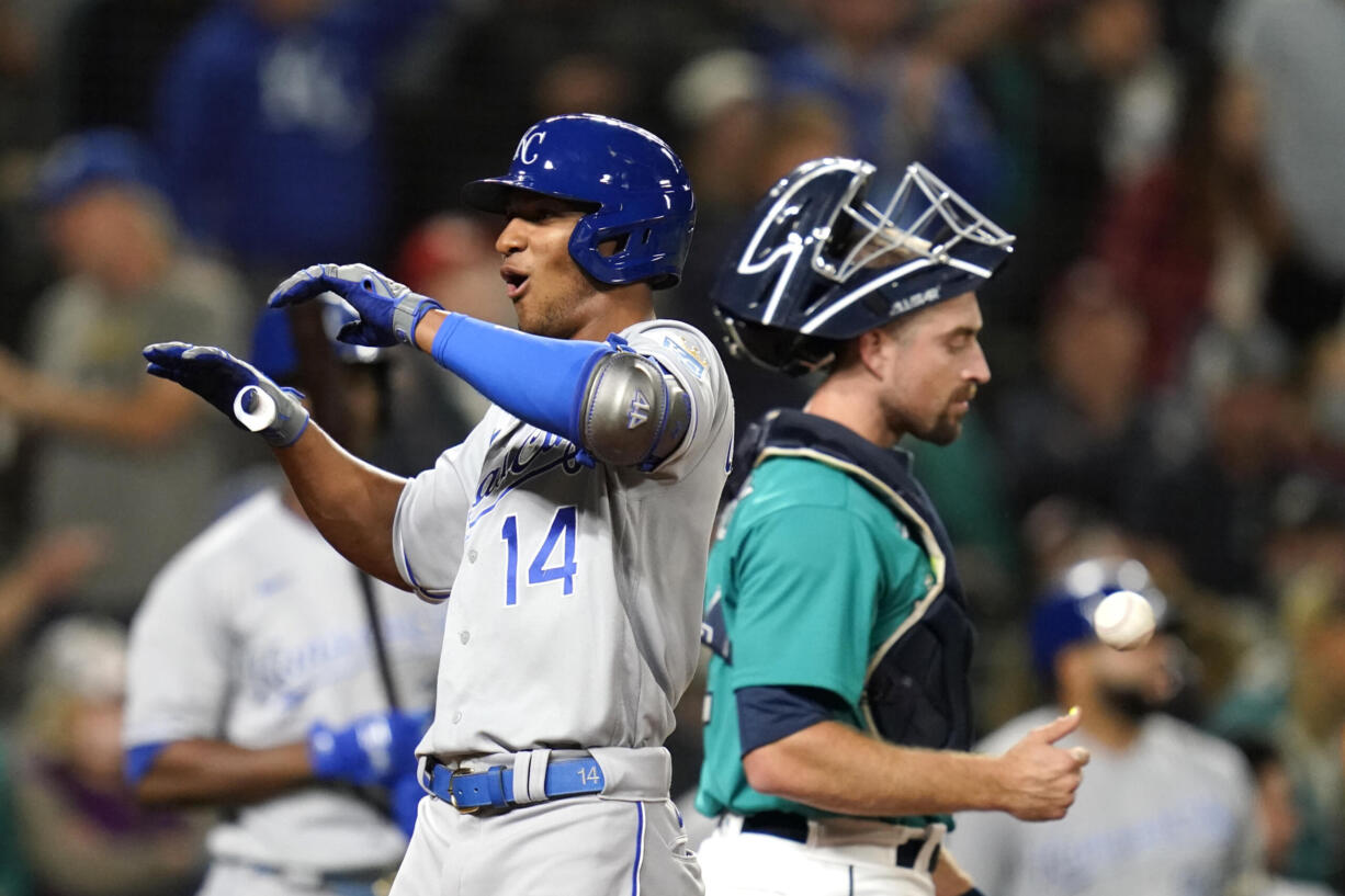 Kansas City Royals' Edward Olivares (14) celebrates his two-run home run as Seattle Mariners catcher Tom Murphy looks away in the 12th inning of a baseball game Friday, Aug. 27, 2021, in Seattle.