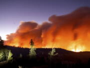 Seen in a long camera exposure, the Caldor Fire burns on Sunday, Aug. 29, 2021, in Eldorado National Forest, Calif.