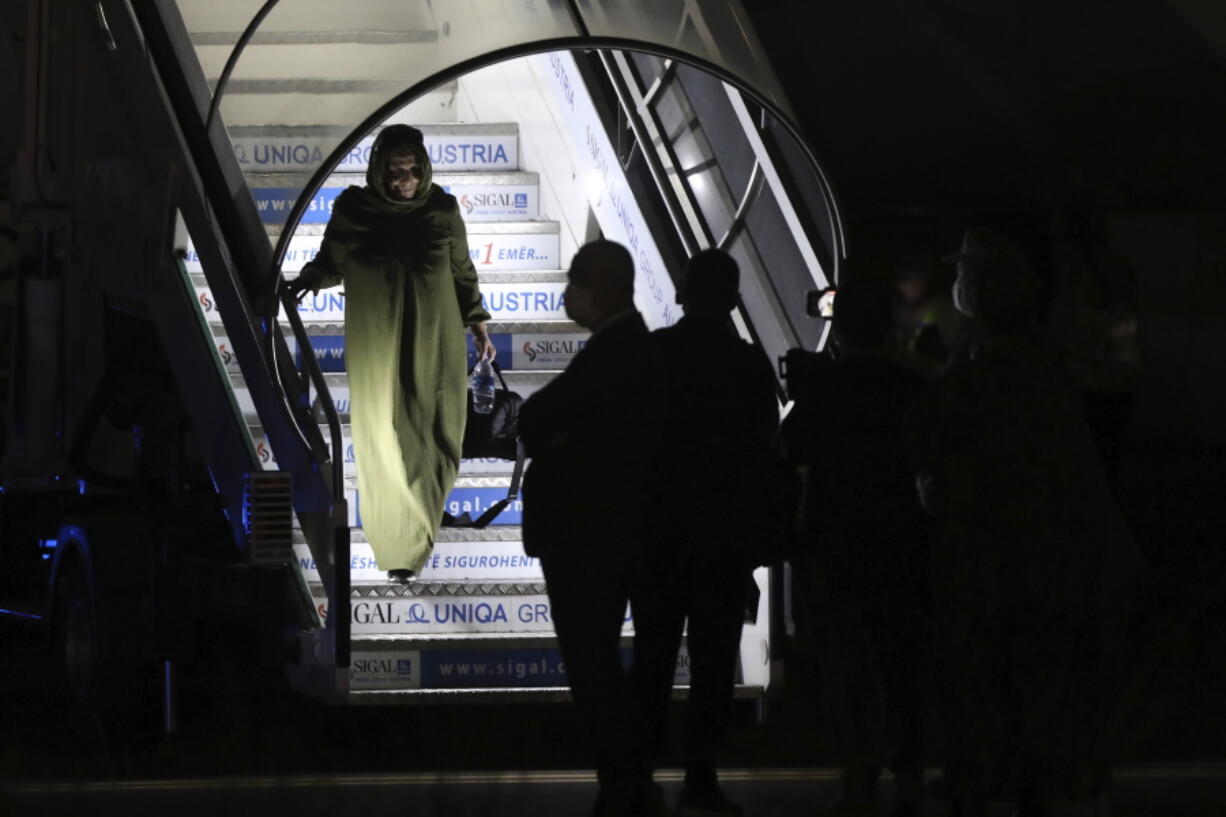 An evacuated citizen from Afghanistan arrives at Tirana International Airport in Tirana, Albania, Friday, Aug. 27, 2021. A government decision has planned that the Afghans may stay at least a year during which they will proceed with their application for special visas before they move on to the U.S. for final settlement.