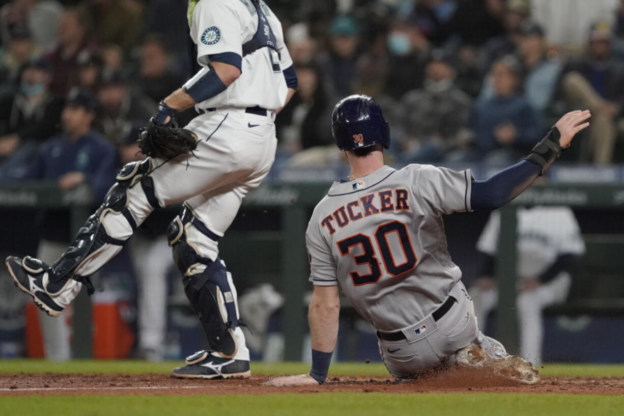 Houston Astros' Kyle Tucker (30) slides home to score on during the eighth inning Monday in Seattle. (Ted S.