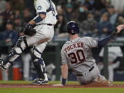 Houston Astros' Kyle Tucker (30) slides home to score on during the eighth inning Monday in Seattle. (Ted S.