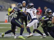 Denver Broncos quarterback Teddy Bridgewater (5) looks for a receiver while under pressure from Seattle Seahawks linebacker Jordyn Brooks (56) during the first half of an NFL preseason football game Saturday, Aug. 21, 2021, in Seattle.