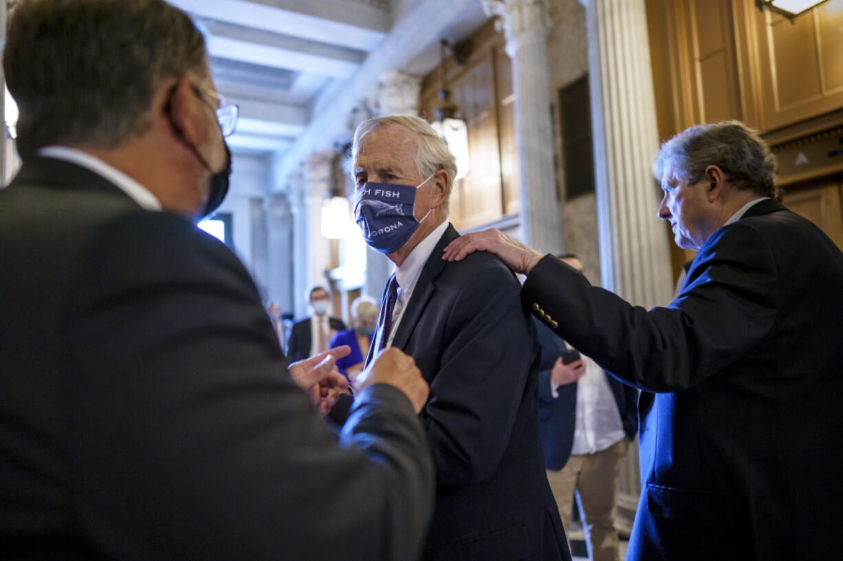 Sen. Angus King, I-Maine, center, speaks with Sen. Gary Peters, D-Mich., left, while Sen. John Kennedy, R-La., walks by at right, as the Senate votes to formally begin debate on a roughly $1 trillion infrastructure plan, a process that could take several days, at the Capitol in Washington, Friday, July 30, 2021. (AP Photo/J.