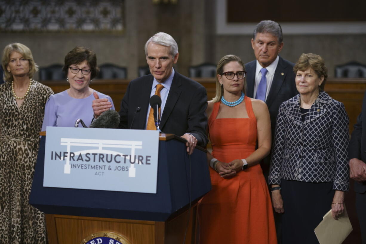 The bipartisan group of Senate negotiators speak to reporters just after a vote to start work on a nearly $1 trillion bipartisan infrastructure package, at the Capitol in Washington, Wednesday, July 28, 2021. From left are Sen. Lisa Murkowski, R-Alaska, Sen. Susan Collins, R-Maine, Sen. Rob Portman, R-Ohio, Sen. Kyrsten Sinema, D-Ariz., Sen. Joe Manchin, D-W.Va., and Sen. Jeanne Shaheen, D-N.H., (AP Photo/J.