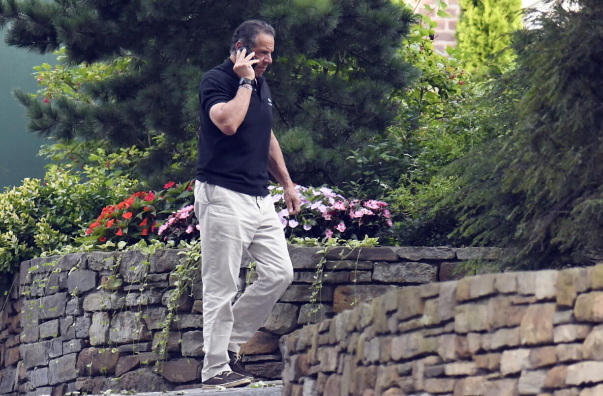 Gov. Andrew Cuomo talks on the phone while walking with his dog Captain at the New York state Executive Mansion, Saturday, Aug. 7, 2021, in Albany, N.Y. An investigation found that Cuomo sexually harassed multiple women in and out of state government.