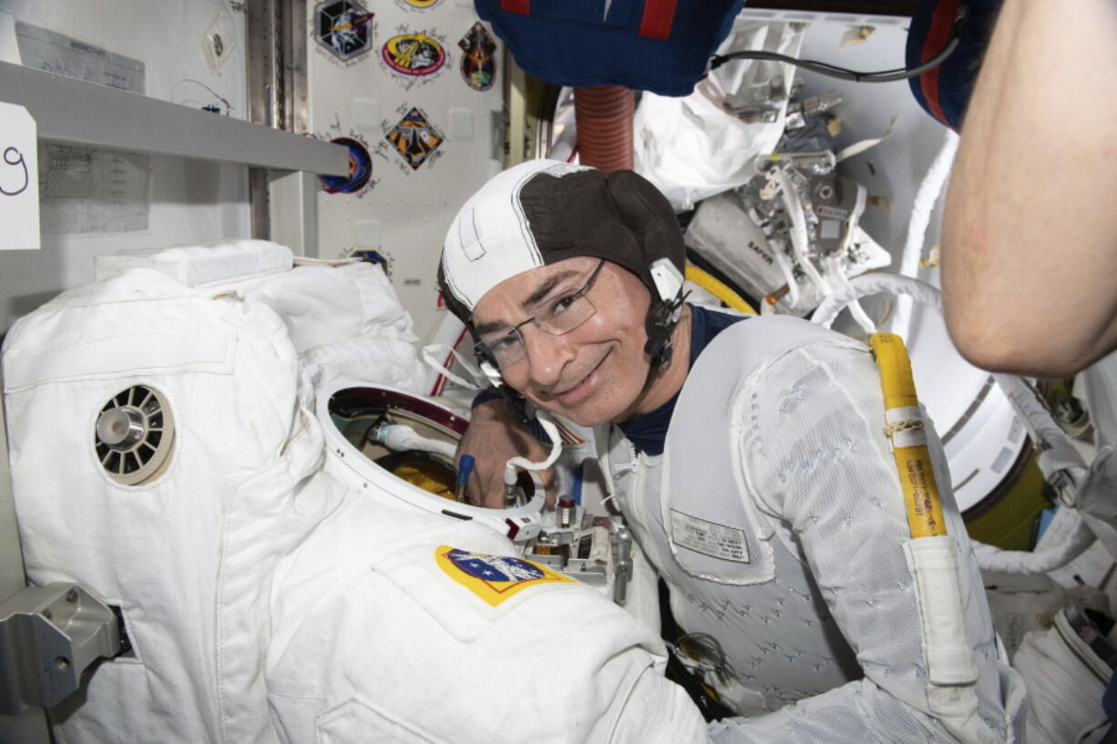 In this Aug. 17, 2021 photo made available by NASA, astronaut and Expedition 65 Flight Engineer Mark Vande Hei inspects a spacesuit in preparation for a spacewalk at the International Space Station. On Monday, Aug. 23, NASA announced it is delaying a spacewalk this week because of an undisclosed medical issue involving Vande Hei.