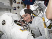 In this Aug. 17, 2021 photo made available by NASA, astronaut and Expedition 65 Flight Engineer Mark Vande Hei inspects a spacesuit in preparation for a spacewalk at the International Space Station. On Monday, Aug. 23, NASA announced it is delaying a spacewalk this week because of an undisclosed medical issue involving Vande Hei.