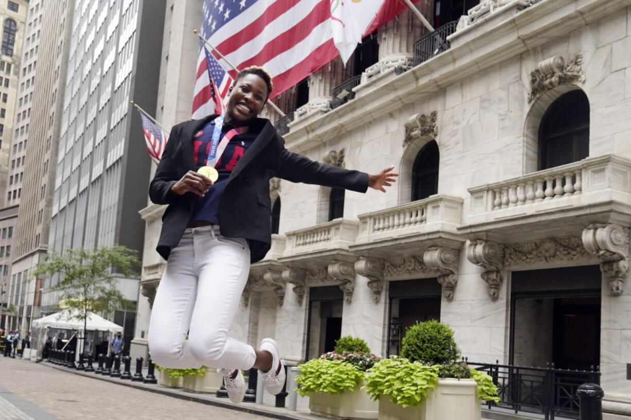 USA Women's Olympic Water Polo Goalkeeper Ashleigh Johnson holds her gold medal as he jumps, while posing for photos outside the New York Stock Exchange, before ringing the opening bell, Tuesday, Aug. 10, 2021.