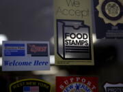 FILE - In this Jan. 12, 2015 file photo, a supermarket displays stickers indicating they accept food stamps in West New York, N.J. The Biden administration has approved a significant and permanent increase in the levels of food stamp assistance available to needy families--the largest single increase in the program's history. Starting in October 2021, average benefits for food stamps (officially known as the SNAP program) will rise more than 25 percent above pre-pandemic levels.