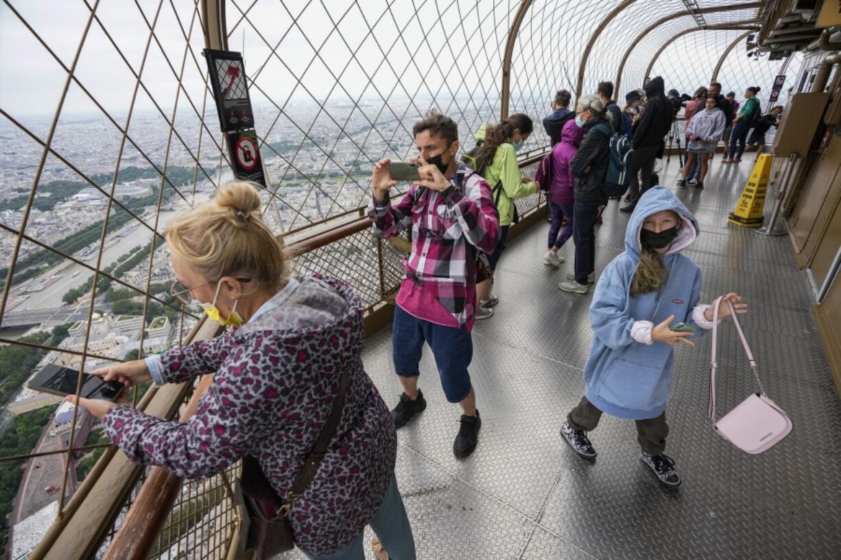 FILE - In this Friday, July 16, 2021 file photo, visitors enjoy the view from top of the Eiffel Tower in Paris. The European Union is expected to recommend that its member states reinstate restrictions on tourists from the U.S. because of rising coronavirus infection levels in the country, EU diplomats said Monday, Aug. 30.