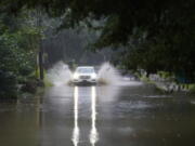 A car attempts to drive through flood waters near Peachtree Creek near Atlanta, as Tropical Storm Fred makes its way through north and central Georgia on Tuesday, Aug. 17, 2021.