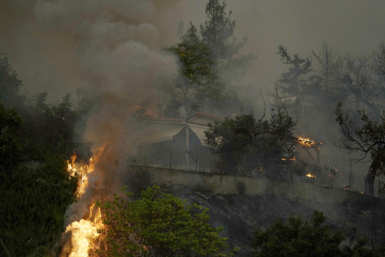 A house is on fire during a wildfire in Afidnes village, about 31 kilometres (19 miles) north of Athens, Greece, Friday, Aug. 6, 2021. Thousands of residents of the Greek capital have fled to safety from a wildfire that burned for a fourth day north of Athens as crews battle to stop the flames reaching populated areas, electricity installations and historic sites.