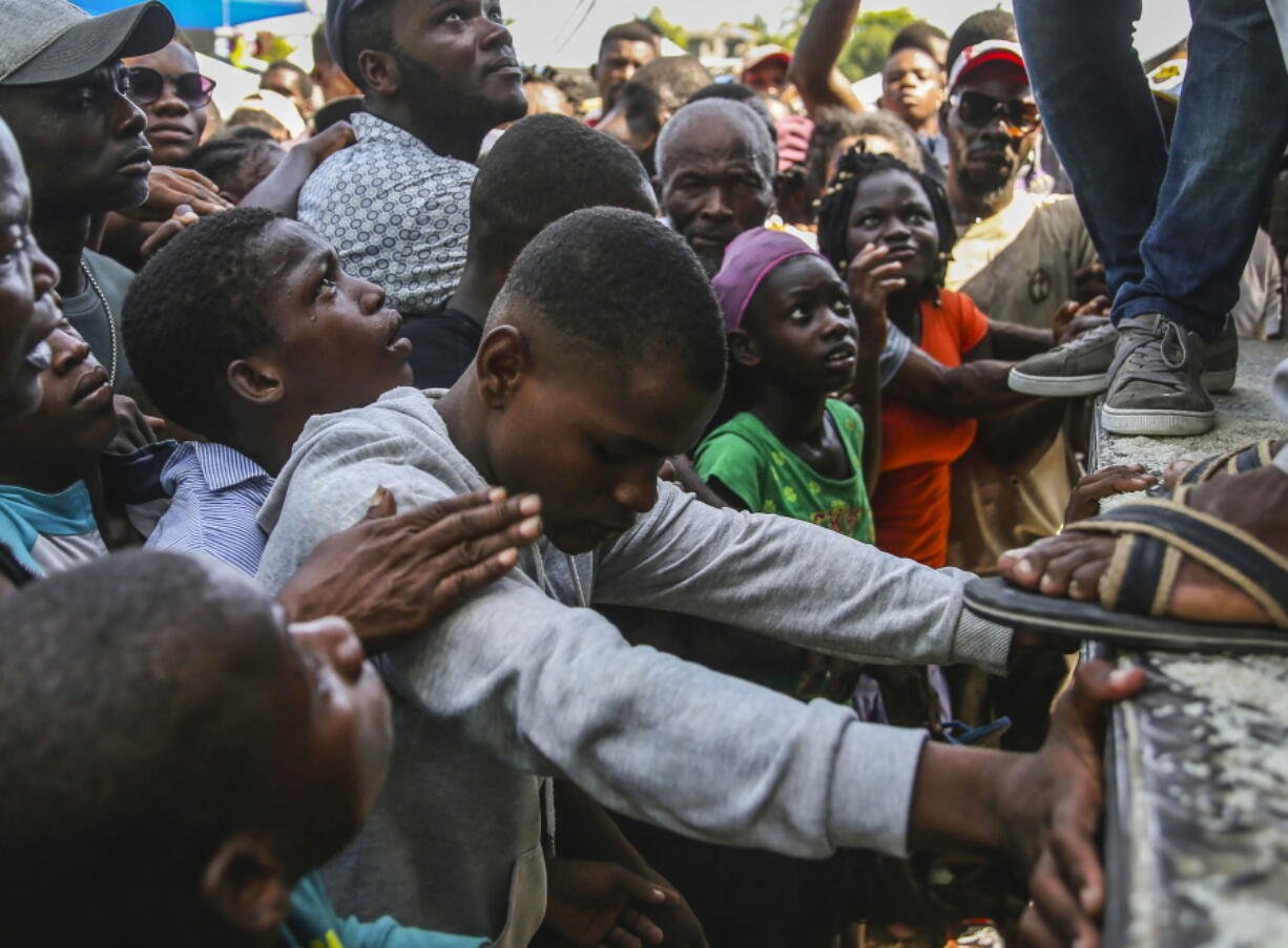 A youth cries as he waits for a sack of rice being distributed to residents in Les Cayes, Haiti, Monday, Aug. 16, 2021, two days after a 7.2-magnitude earthquake struck the southwestern part of the hemisphere's poorest nation on Aug. 14.