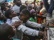 A youth cries as he waits for a sack of rice being distributed to residents in Les Cayes, Haiti, Monday, Aug. 16, 2021, two days after a 7.2-magnitude earthquake struck the southwestern part of the hemisphere's poorest nation on Aug. 14.