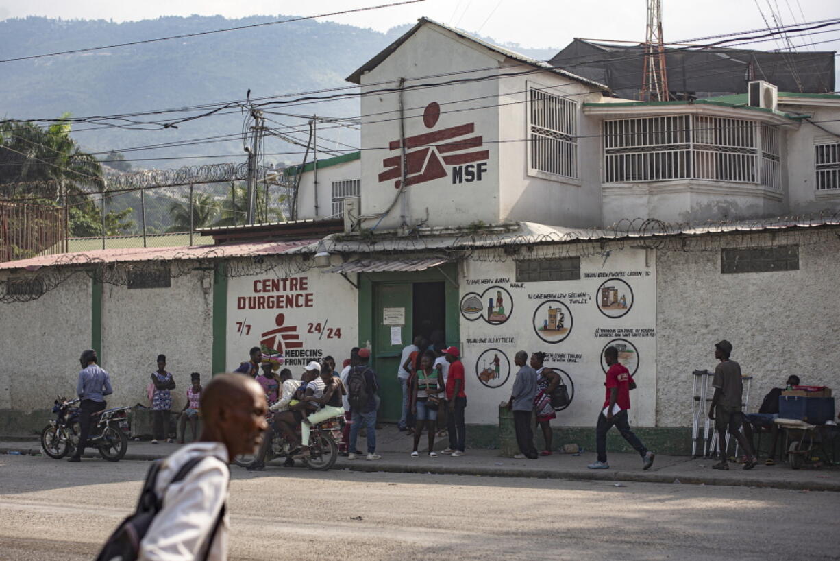 This photo provided by Doctors Without Borders shows locals standing outside its emergency clinic in the Martissant neighborhood of Port-au-Prince, Haiti, Sunday, Dec. 2, 2020. Officials said Monday, August 2, 2021, that Doctors Without Borders has closed the Martissant emergency clinic in Haiti's capital amid gang violence that has left more than 19,000 people homeless.