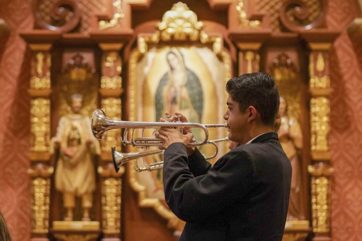 Los Changuitos Feos (Ugly Little Monkeys) mariachi band members Roman Murillo 14, and Cameron Davison 18, play their trumpets as they preform during the morning Mass at St. Augustine Cathedral Sunday, Aug. 18, 2021 in downtown Tucson. After more than a year of silence due to the pandemic, mariachis are back playing Sunday services at the cathedral, where the colorful and sonorous tradition dates back a half-century and fuses Roman Catholicism with Mexican American pride.