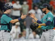 Seattle Mariners relief pitcher Yohan Ramirez, right, celebrates with catcher Cal Raleigh after a baseball game against the Houston Astros Sunday, Aug. 22, 2021, in Houston. The Mariners won 6-3 in 11 innings. (AP Photo/David J.