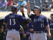 Seattle Mariners' Abraham Toro, left, celebrates with Kyle Seager after both scored on a two-run single by Luis Torrens during the third inning of a baseball game against the Oakland Athletics in Oakland, Calif., Tuesday, Aug. 24, 2021.